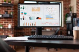 Close up of desk with business analysis charts on computer.