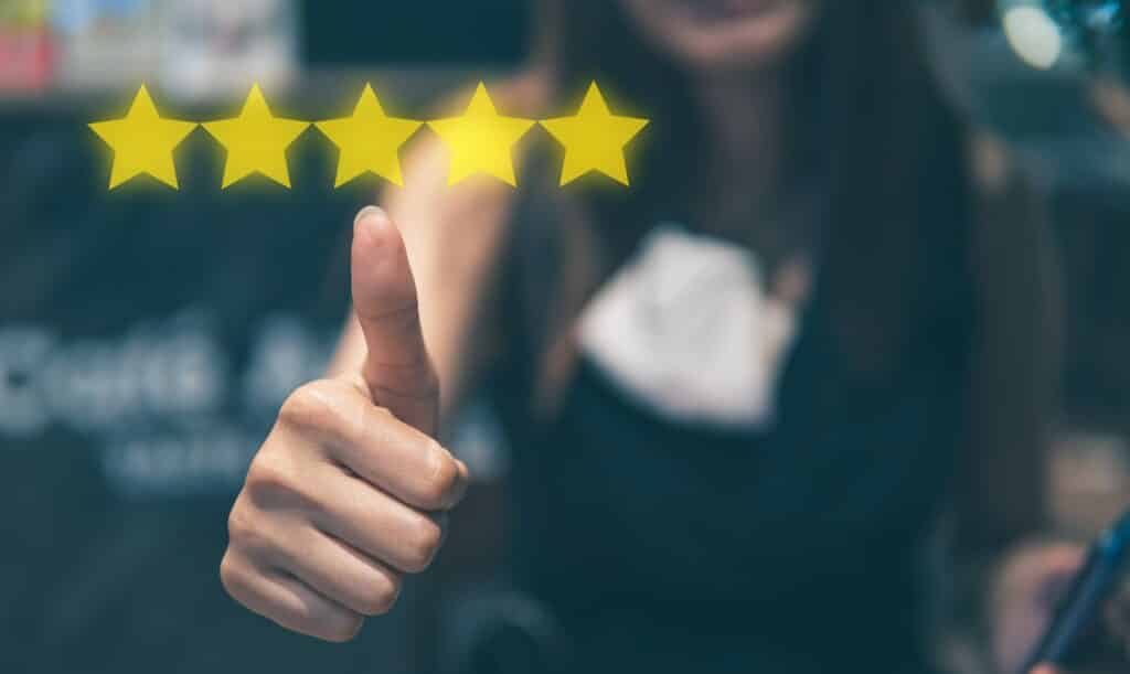 online reviews concept with closeup of thumbs up and 5 star review