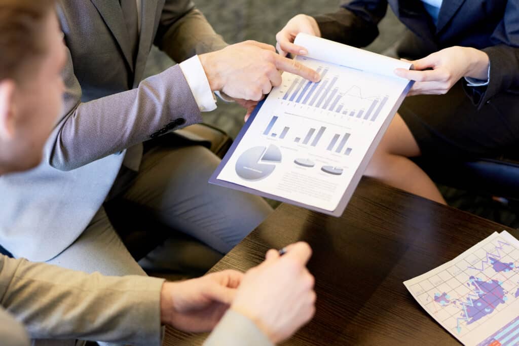 High angle close up of business team and marketing company discussing statistics report during marketing meeting in office