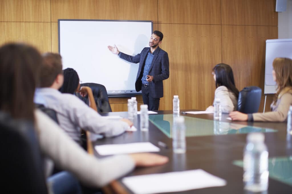 Manager leading business meeting in boardroom discussing b2b leads