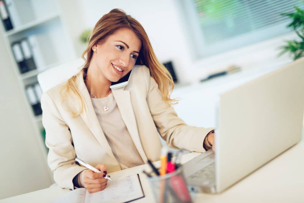 Businesswoman working online with a laptop and phone discussing AI conversions