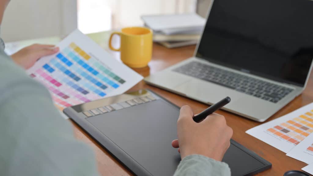 branding agency concept with woman reviewing branding colors next to a laptop
