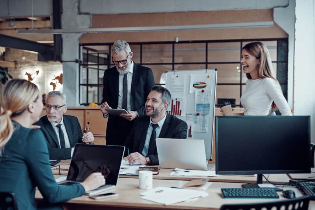 Web marketing professionals in elegant formalwear discussing fresh business ideas while working in the office