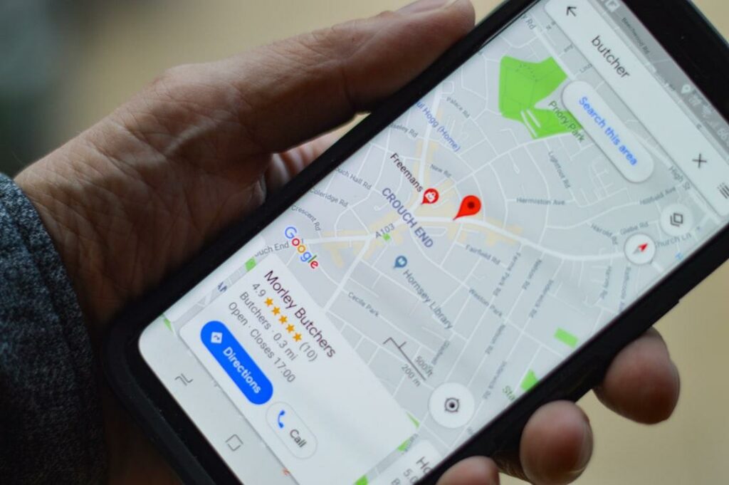 Google Reviews concept with star rating on a cell phone in hand.